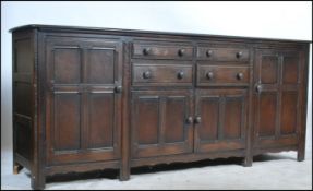 A 20th century Ercol Old Colonial beech and elm wood large sideboard having chamfered edge top