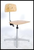 A vintage mid 20th Century industrial machinist chair, panel seat pad and back rest raised on an