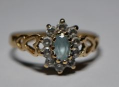 A hallmarked 9ct gold cluster ring having a central blue stone with a halo of white stones.