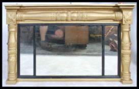 An antique style large ornate over mantle mirror having a gilt plaster and wood frame with columns