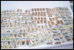 A shoe box of vintage cigarette cards including sets part sets and odd cards. Many hundred good