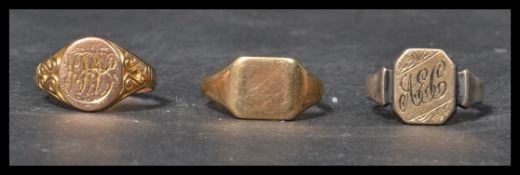 A group of three vintage early 20th century signet rings , two being 9ct gold and the other being