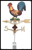 A cast metal weather vane with a cockerel to the top. Measures 73 cm high.