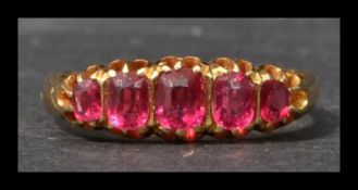 A hallmarked Edwardian 18ct gold and pink stone ring having 5 graduated pink stones in a gypsy
