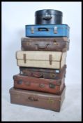 A stack of 20th century vintage suitcases / trunks to include early leather example, mid century
