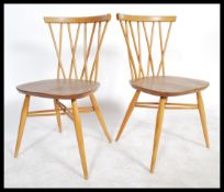 Ercol - Model 376 - A vintage pair of beech and elm candlestick chairs having crossed spindle backs,