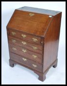 A 19th century Georgian mahogany bureau being raised on bracket feet with a bank of drawers having