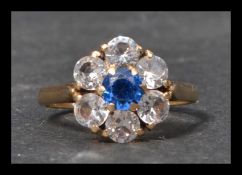 A 9ct gold cluster ring set with a central round brilliant cut stone surrounded by a halo of white