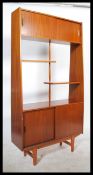 A 1960's Danish teak wood room divider bookcase being raised on tapered legs with cupboard base with