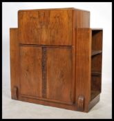 A 1930's Art Deco walnut cocktail drinks cabinet. The breakcentre metamorphic cabinet with appointed