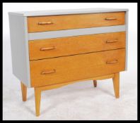 A vintage / retro 20th Century teak chest of three graduating drawers finished with a contrasting