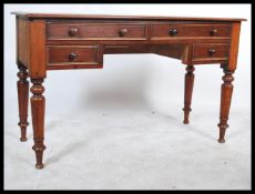A 19th century Victorian mahogany writing desk raised on turned column legs with two long over two