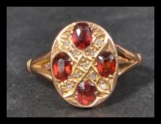 A hallmarked early 20th century 9ct gold ring set with oval orange red stones and rose cut diamonds.