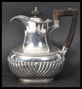 A Victorian silver hallmarked hot water jug of oval form with half reeded decoration by James Dixon.