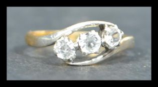 An 18ct gold and platinum three stone crossover ring. Stamped to inside of shank. Weighs 1.9 grams