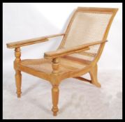 A 20th Century vintage hardwood Plantation chair / armchair with 2 slide out arms being raise on