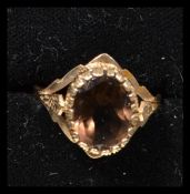 A hallmarked 9ct gold dress ring having a large central faceted citrine / smokey quartz with split