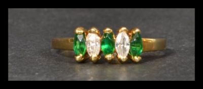 A hallmarked 18ct gold ring being set with green and white marquise cut stones. Weight 2.7g. Size