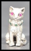 A sterling silver pin cushion pincushion in the form of a cat having inset ruby eyes in the manner