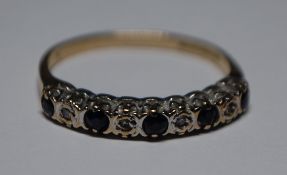 A hallmarked 9ct gold diamond and sapphire ring having alternating illusion set diamonds and blue