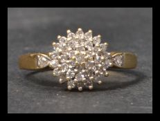 A hallmarked 18ct gold and diamond cluster ring having round cut diamonds set in concentric