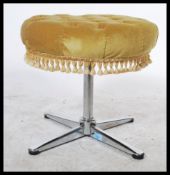 A retro 1970's chrome footstool raised on a quadruped base with splayed feet having a velour