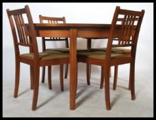 A retro 20th Century teak wood dining suite comprising of an extendable table together with four