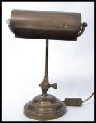 A vintage mid century brass bankers lamp raised on terraced base having angular and adjustable