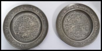 Two 19th century middle eastern pewter plates having silver overlaid decoration. Central