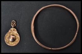 A 9ct gold Henry Griffith and Sons 9ct gold bangle along with a hallmarked 9ct gold fob medal/.