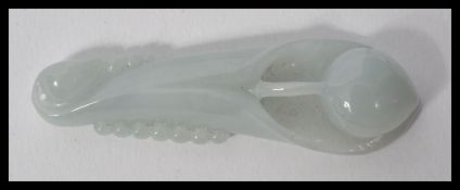 A carved Chinese jade pendant in the form of a posy flower in a light green pale colour.