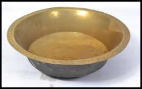 A 19th century large Persian Islamic Middle Eastern brass temple wash bowl having a rounded bottom