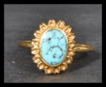 An 18ct gold and turquoise ring. Marked 750 140AR. Size O. Weight 3.3g.