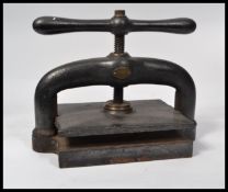A Victorian 19th century ebonised cast iron and Gunmetal book press with screw and large handle.