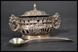 A silver hallmarked twin handled fret pierced lidded mustard pot with blue glass liner, Birmingham