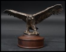 A vintage 20th century desk top paperweight in the form of a silver plated eagle raised on a