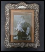 A large early 20th century silver hallmarked picture frame decorated with scrolls with unengraved