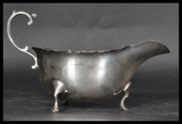 An Edwardian hallmarked silver sauce boat / creamer jug with cast shaped rim and S-scroll handle,