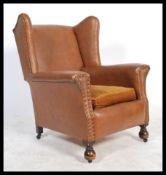 An Edwardian early 20th century club armchair being raised on turned legs with castors and