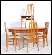 A retro 1970's teak wood extending dining table of oval form raised on tapering legs with