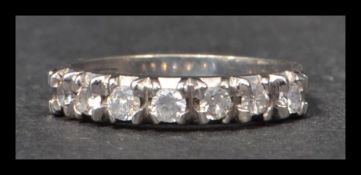 A hallmarked 9ct white gold and white stone half eternity ring set with 7 white stones. Weight 3.1g.