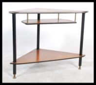A vintage 20th Century triangular three tiered corner shelving unit raised on ebonised tapering