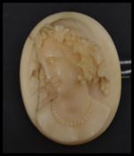 A 19th century Victorian hand carved ivory cameo brooch featuring a maiden facing left on brass
