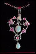 A sterling silver pendant necklace set with ruby and opal of scrolled foliage form complete in