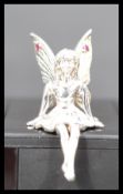 A sterling silver figurine of a fairy modeled in a seated position. Stamped 925 weighs 10.5 grams.