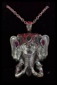 A sterling silver elephant mask pendant on silver necklace chain set with marcasites , rubies and