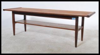 A vintage retro 20th Century teak wood coffee table of oblong form raised on shaped tapering