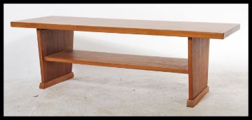 A retro mid century Danish influenced teak wood coffee table of rectangular form raised on