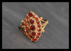 A hallmarked early 20th century 9ct gold ring set with orange red stones in a boat shaped setting.