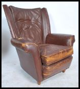 A mid century leather upholstered club armchair. The chair raised on castors to the base with shaped